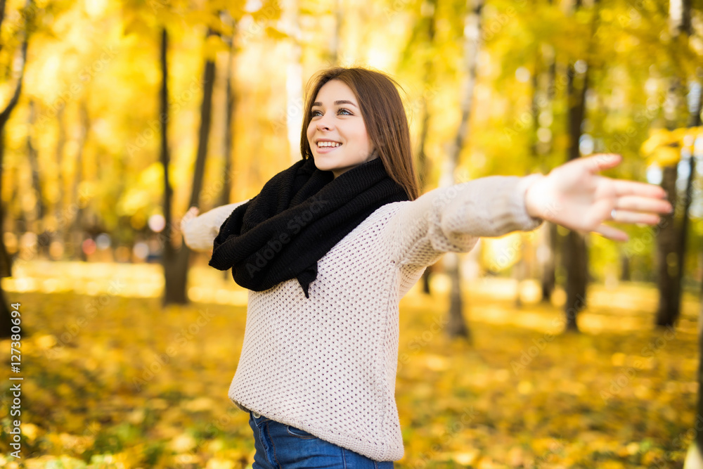 Exited young girl with rised hands in autumn park Exited young girl with rised hands in autumn park