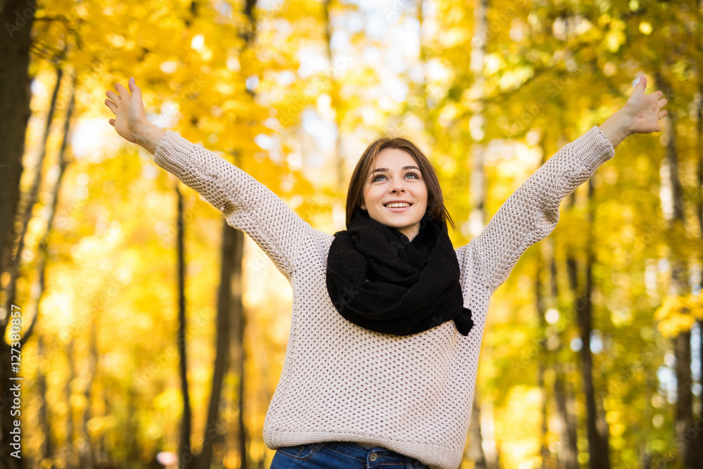 Exited young girl with rised hands in autumn park Exited young girl with rised hands in autumn park