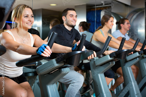 Group positive working out of cycling in fitness club