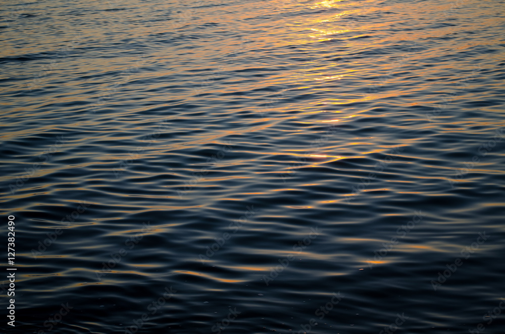 Texture of sea water at sunset, blue and orange colors of sun path Texture of sea water at sunset, blue and orange colors of sun path