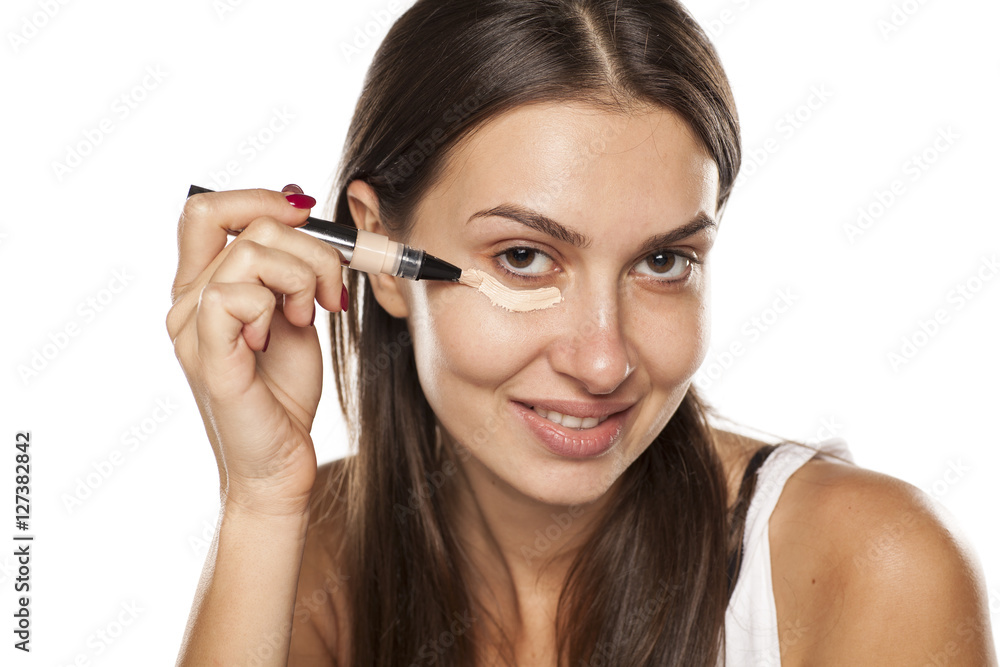 young women applied concealer under the eyes with applicator young women applied concealer under the eyes with applicator