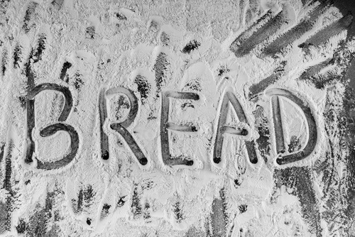 Word bread written in flour on table