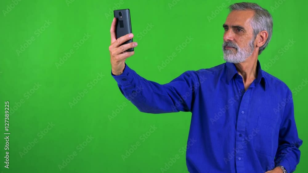 old senior man photographs with smartphone (selfie) - green screen - studio old senior man photographs with smartphone (selfie) - green screen - studio