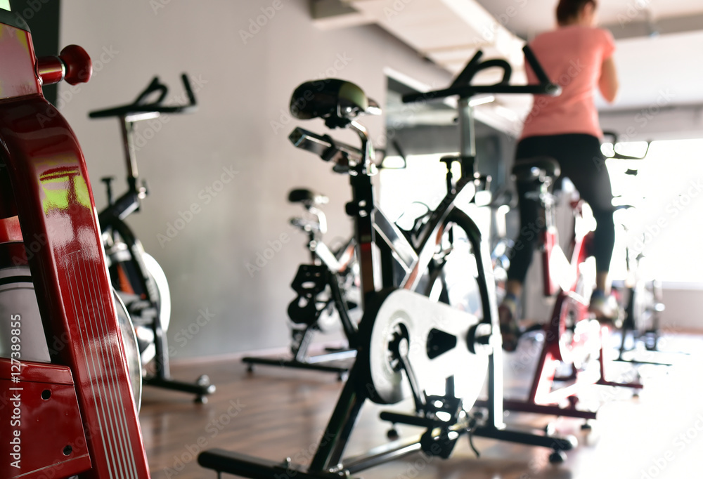 Obraz premium Young girl is doing sport Spinning in the gym for fitness