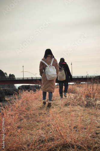 travelers with backpacks walking through golden field