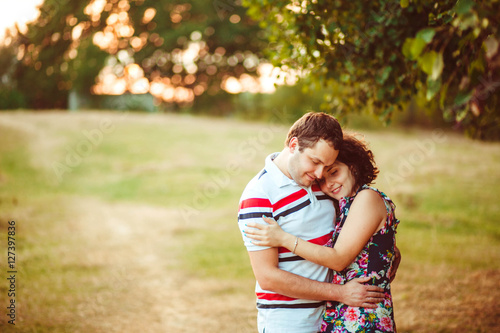 beautiful and happy wife and husband hug each other outdoors