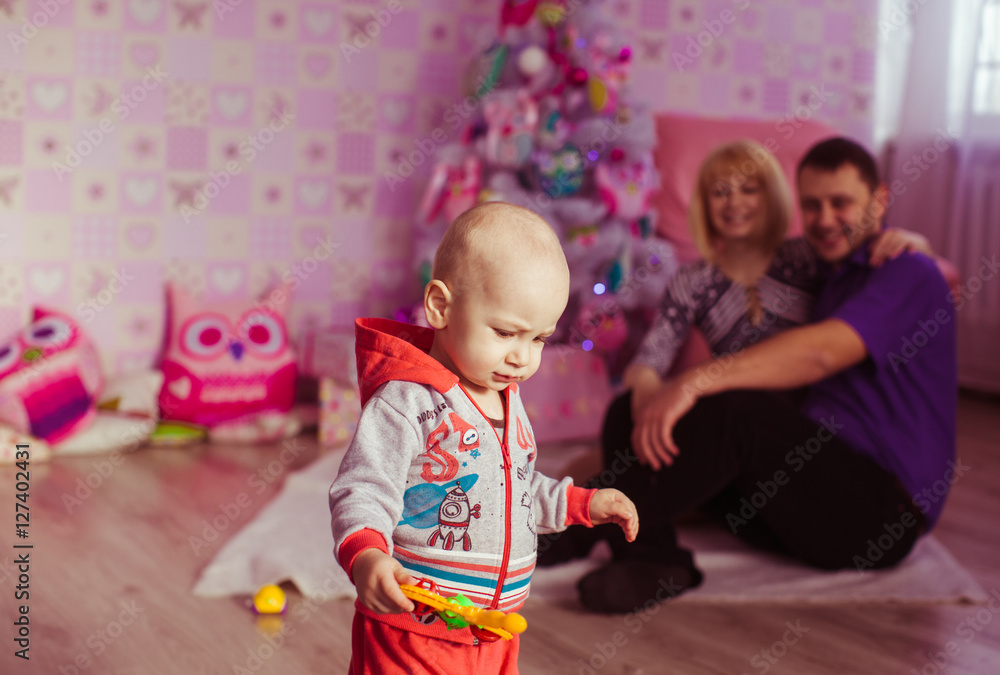 Fototapeta premium little boy playing near xmas tree