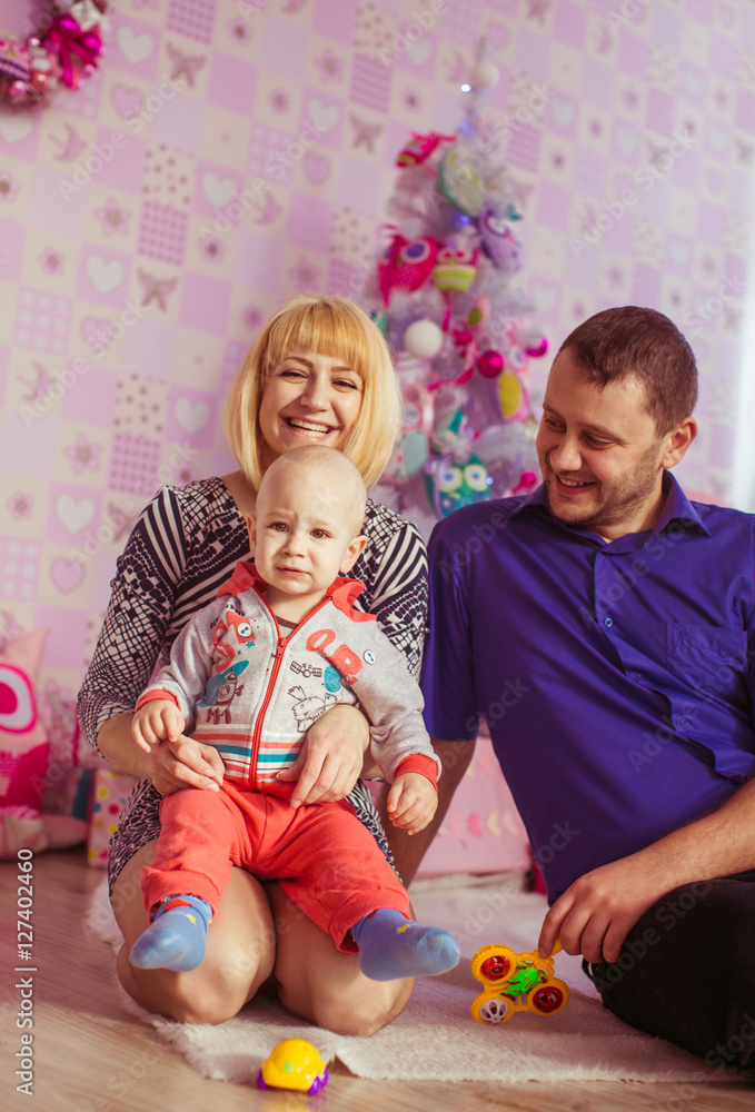 Naklejka premium mother, father and little boy on the background of the Christmas