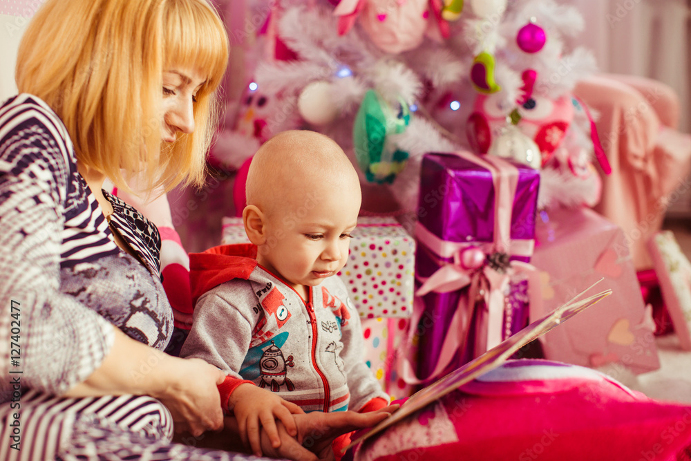 young attractive mother and her cute son reading a book young attractive mother and her cute son reading a book