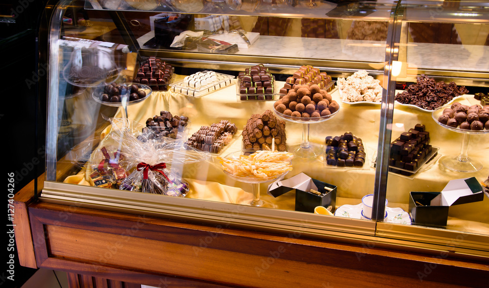 Handmade chocolate display case in a European confectionery, selective focus