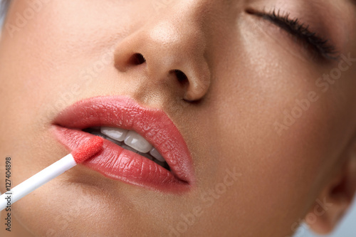 Fotografie Beauty Makeup. Beautiful Woman Applies Lip Gloss