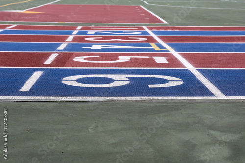 Running track with numbers from 1 to 6. Shot in a unique angle. Blue  red  white and green colors. 