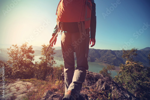 young woman backpacker trekking at mountain peak