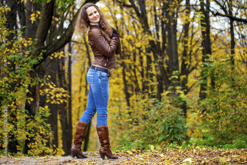 Autumn fashion image of young woman walking in the park Autumn fashion image of young woman walking in the park