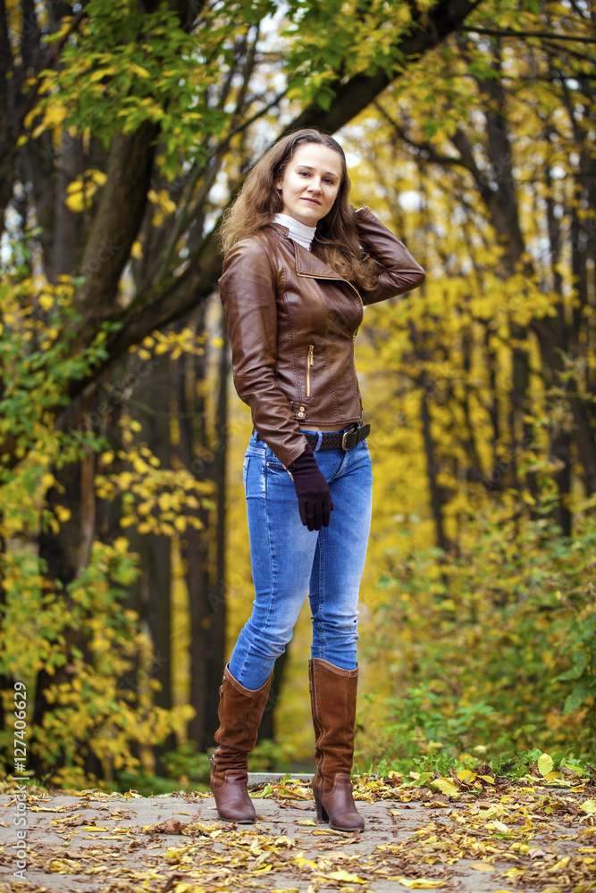 Autumn fashion image of young woman walking in the park Autumn fashion image of young woman walking in the park