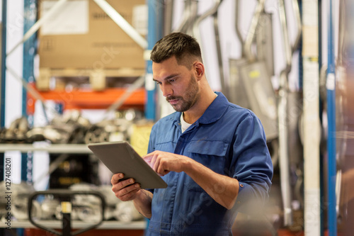 Fotografie auto mechanic or smith with tablet pc at workshop