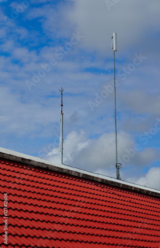 Lightning rod and white color antenna repeater tower on a roof