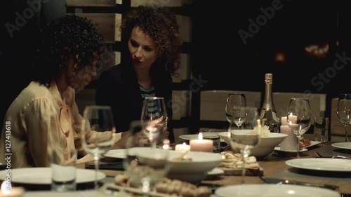 Multiethnic group of friends attending a dinner party. 
