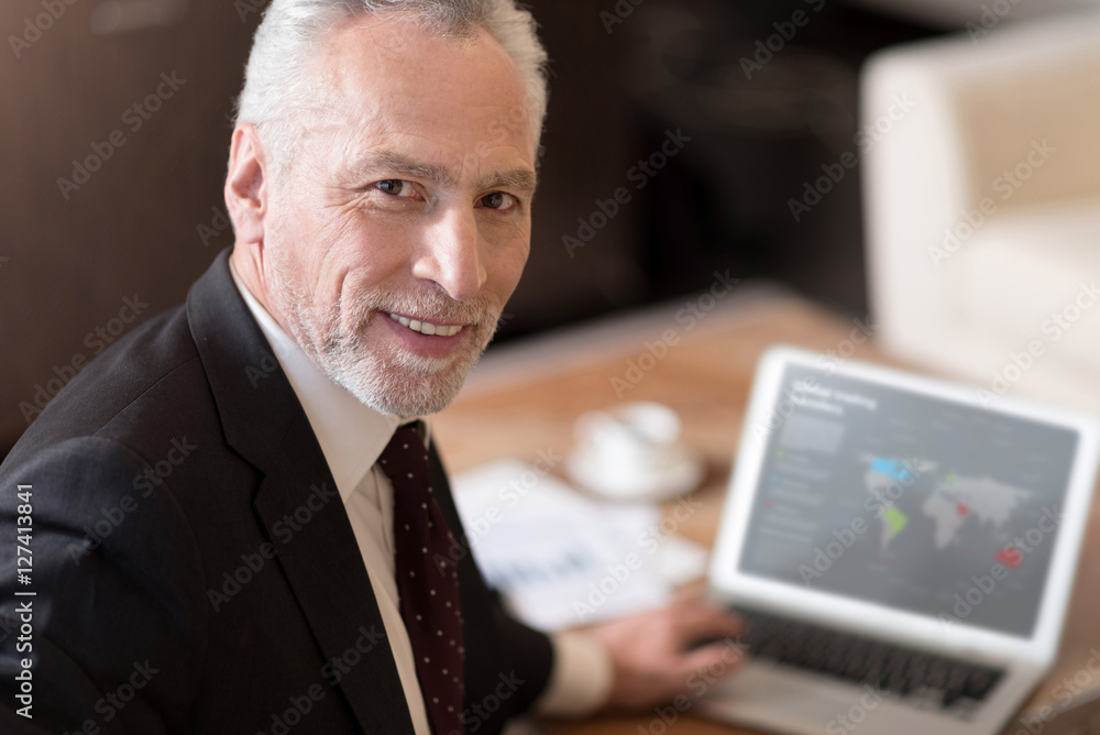 Smiling businessman working with the laptop in the hotel Smiling businessman working with the laptop in the hotel