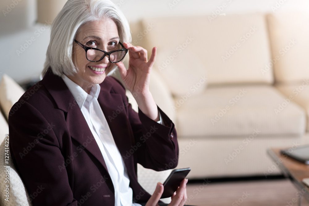 Joyful businesswoman holding the glasses and smiling Joyful businesswoman holding the glasses and smiling
