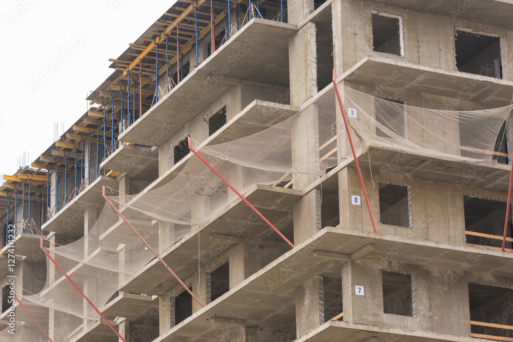 Fototapeta premium Protective guard from falling objects during the construction of multi-storey residential building
