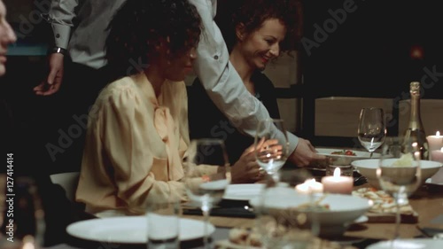 Multiethnic group of friends attending a dinner party. 
