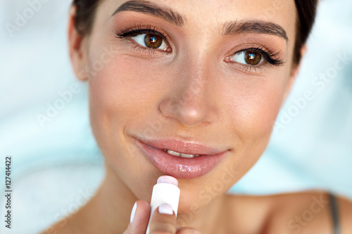 Photos Beautiful Woman With Beauty Face Applies Balm On Lips. Skin Care