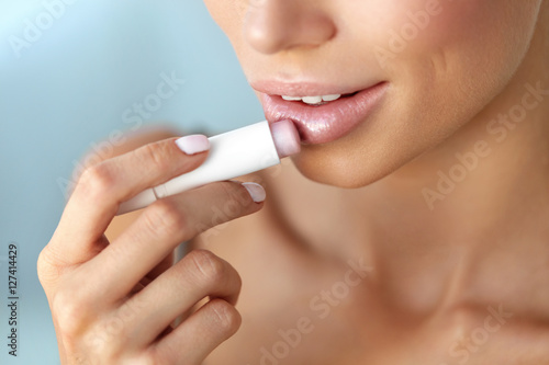Beautiful Woman Applying Lip Protector On Lips Skin. Beauty