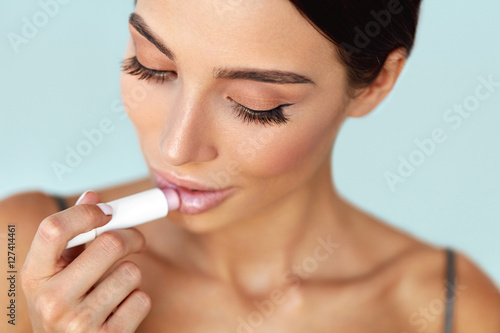 Lips Skin Care. Beautiful Woman Applies Lipbalm Protection On