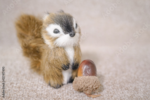 Realistic Miniature Squirrel, Animal Replica Prop Fur Toy, for Decoration, Selective Focus, isolated on soft brown background (copy space, empty space for text on the left) photo