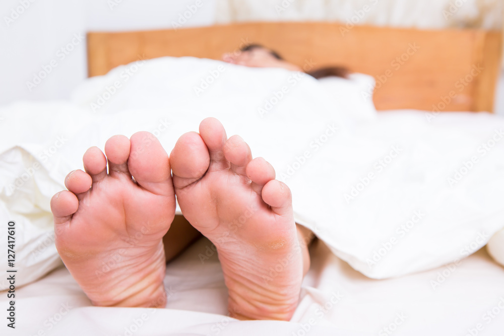 Person's foot in bed Person's foot in bed