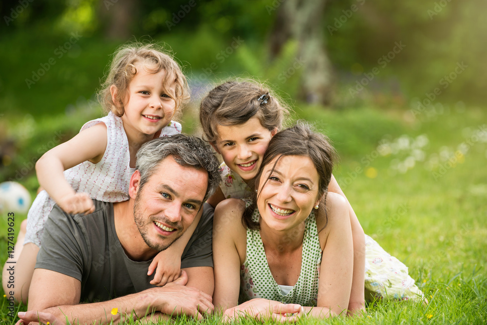 Summertime. happy family lying on the grass in a park Summertime. happy family lying on the grass in a park
