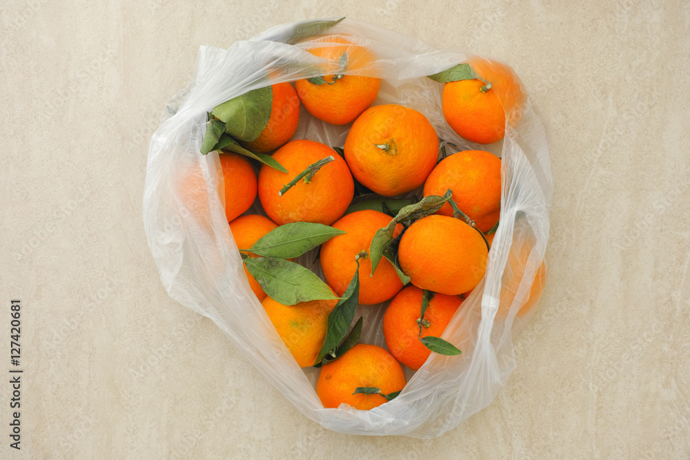 Fresh tangerines with leaves in a plastic bag Stock Photo