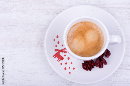 Christmas cup of espresso coffee on white wooden background, top view