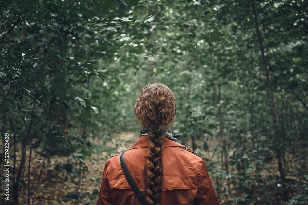 Naklejka premium Young Woman with long hair Walking in Forest. Back View, dramatic image concepte