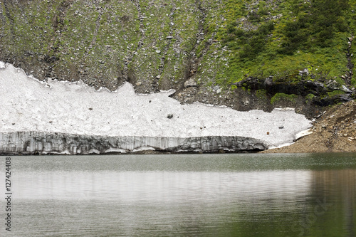 Russia. Khakassia. Sayan Mountains. Reserve Kuznetsky Alatau. Icy mountain lake, originating water from Snowfield.