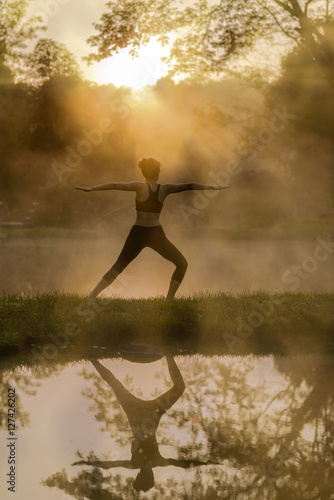 Young woman in silhouette practice yoga in a hot spring
