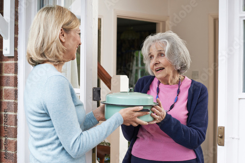 Woman Bringing Meal For Elderly Neighbour
