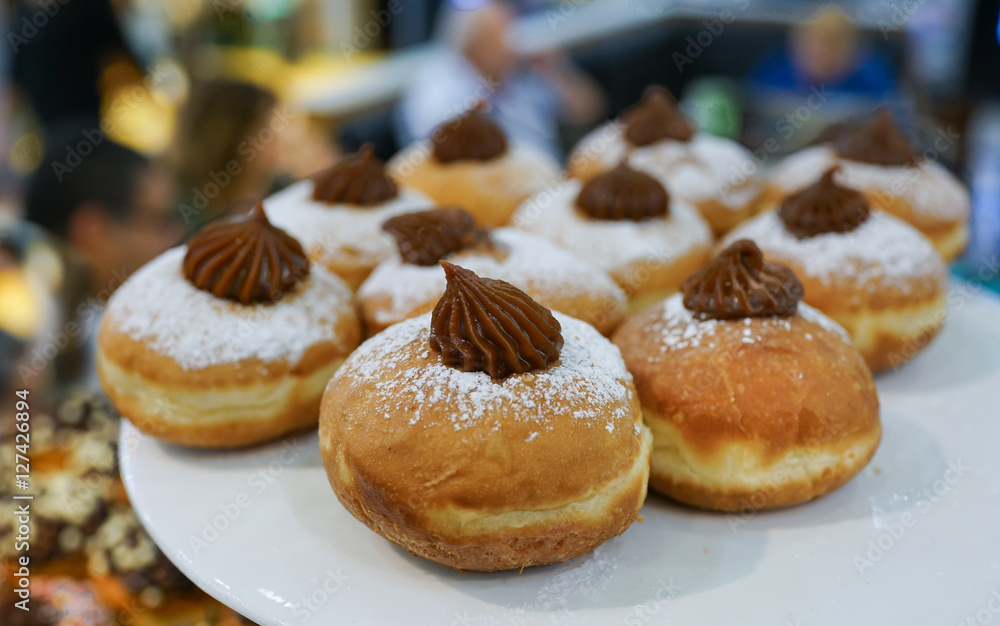 Fresh donuts on bakery display for Hanukkah celebration. Selective focus.
