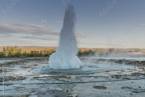 Geysir erupting at sunset in the Golden Circle area of Iceland