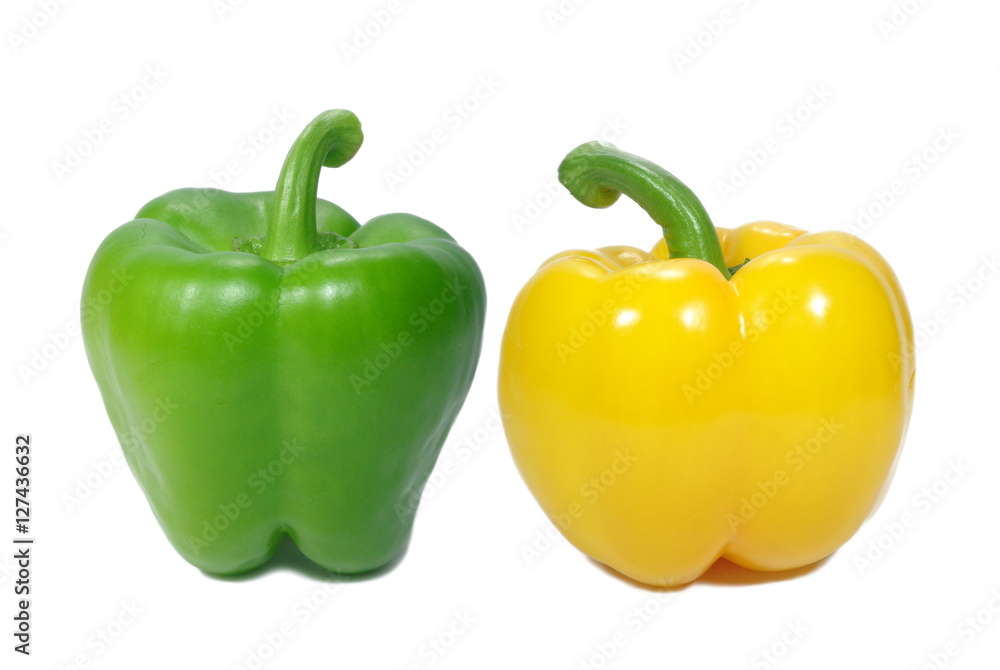 Closed up two ripe bright color bell peppers, one green and one yellow with green stem isolated on white background Closed up two ripe bright color bell peppers, one green and one yellow with green stem isolated on white background