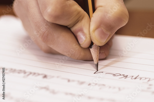 School Boy Writing Close Up. Pencil in Children Hand.