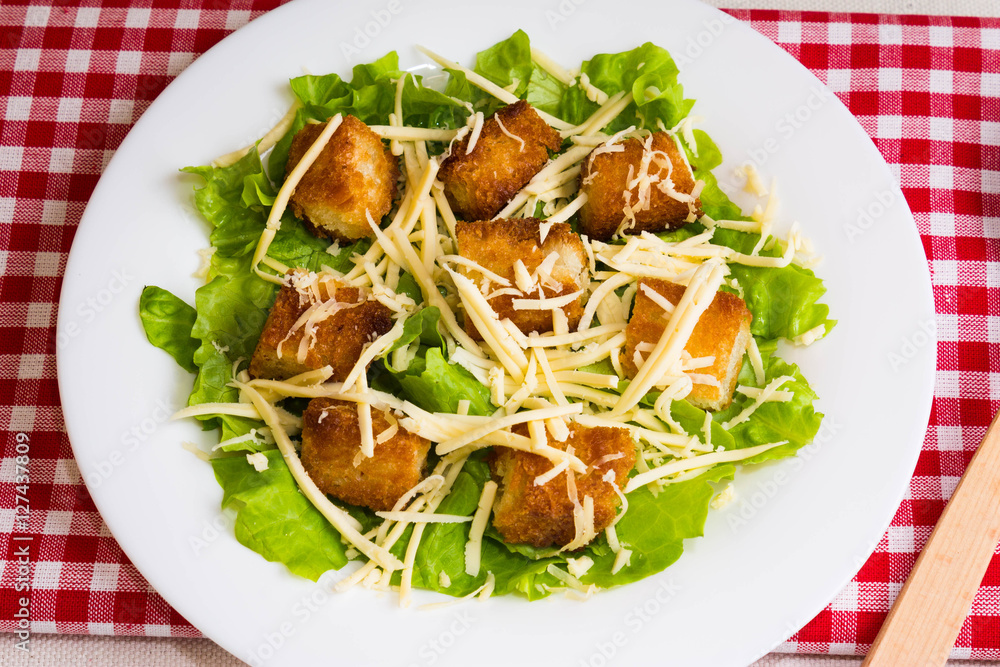 Caesar salad with croutons on a white plate Caesar salad with croutons on a white plate