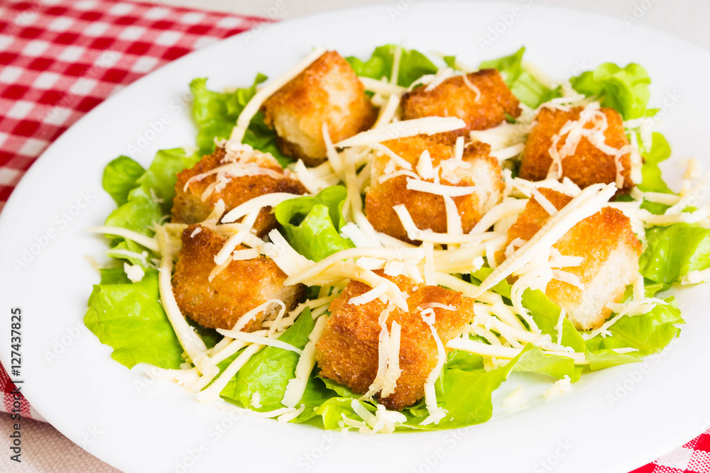 Caesar salad with croutons on a white plate Caesar salad with croutons on a white plate