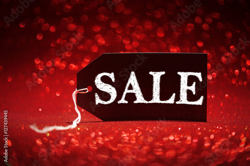 Sale price tag on red glitter background