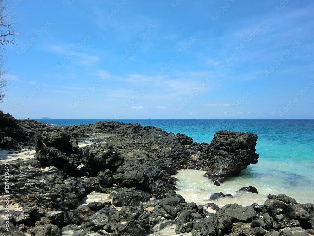 Tranquil blue green water on black volcanic beach Tranquil blue green water on black volcanic beach