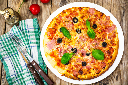 Pizza with prosciutto, tomatoes and mozzarella