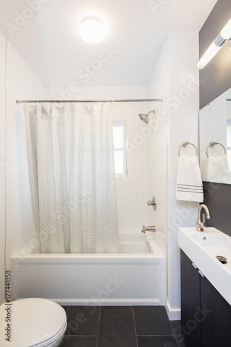 Minimalistic bathroom with narrow sink and shower.