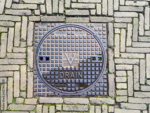 Photography Manhole cover on pavement with patterns, Amsterdam