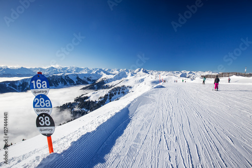 Ski slopes and skiers skiing in Kitzbühel ski resort in Tyrolian Alps photo